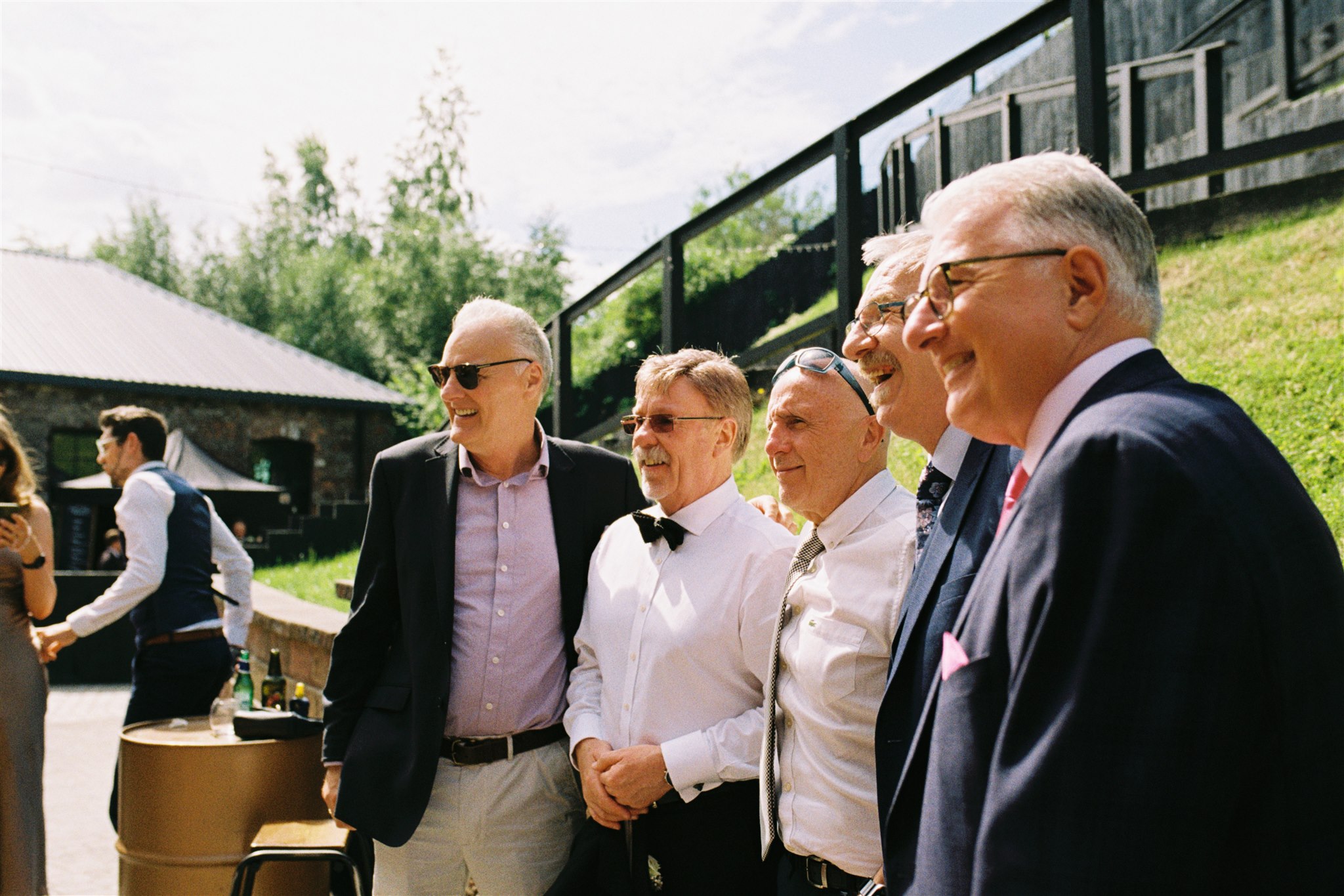 older white male wedding guests standing together in the sunshine at The Engine Works, Glasgow