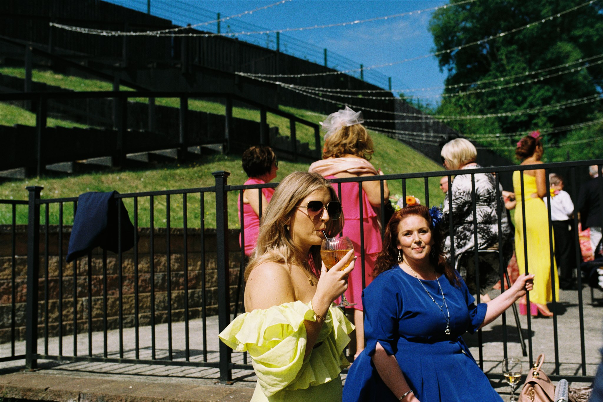 wedding guests in yellow and blue dresses, in the sunshine at The Engine Works, Glasgow