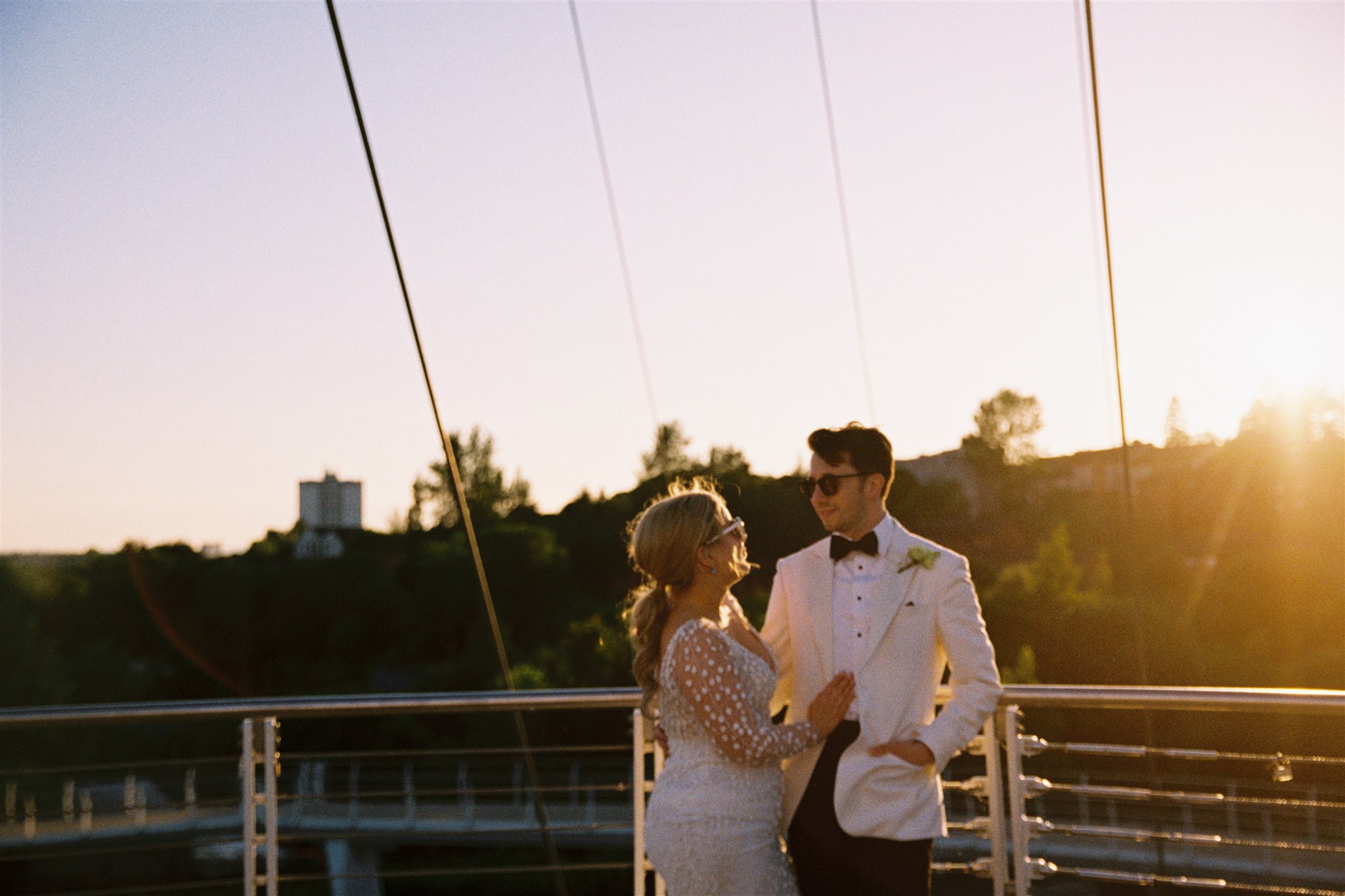 analogue film photography of a bride and groom at Sunset after their wedding, standing by the canal in Glasgow