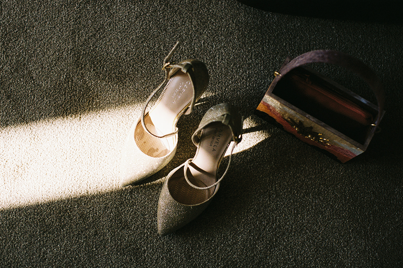 gold carvela shoes in a beam of light on the floor