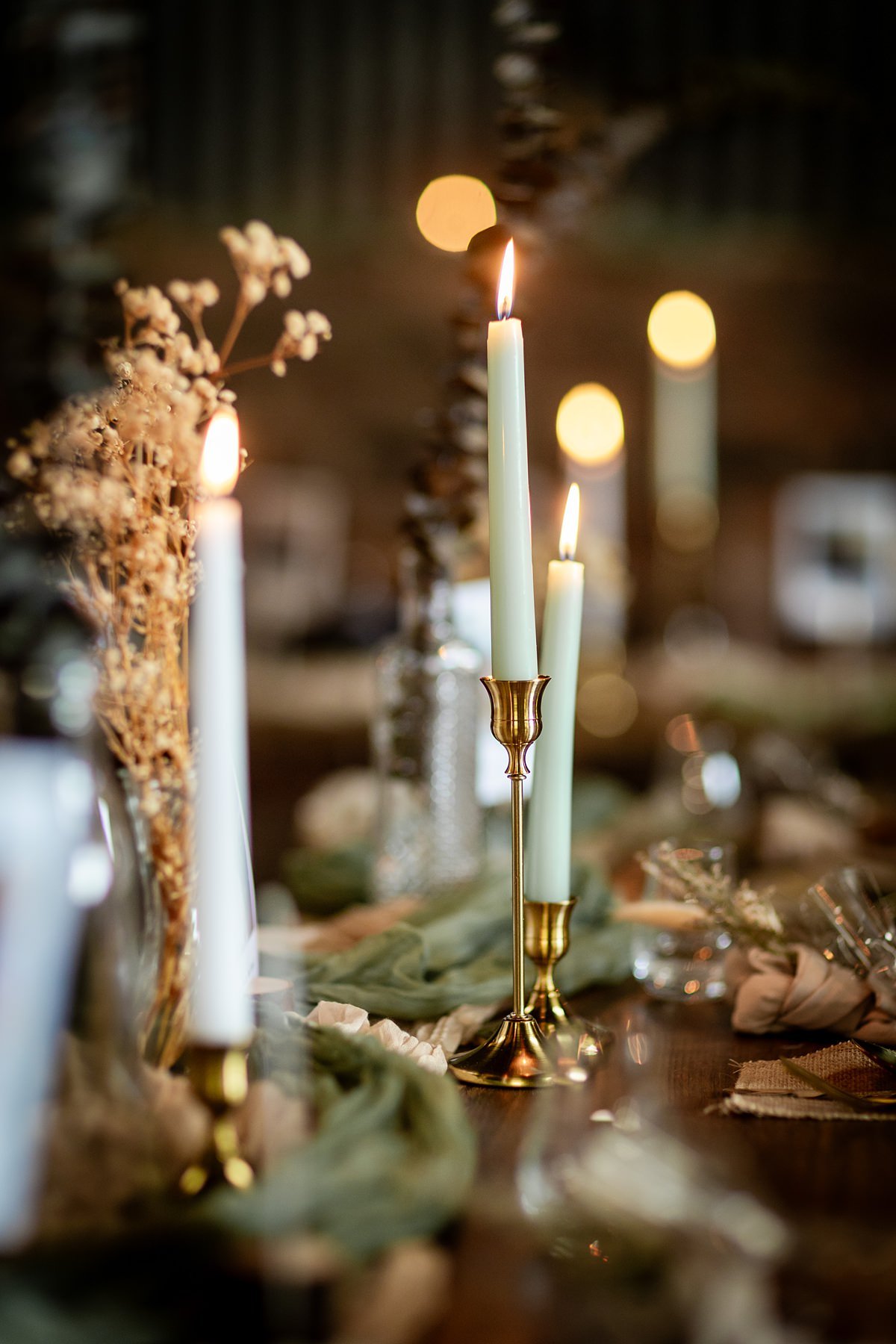 candles, linen table runners and folliage on tables at a DIY Family farm wedding in Scotland
