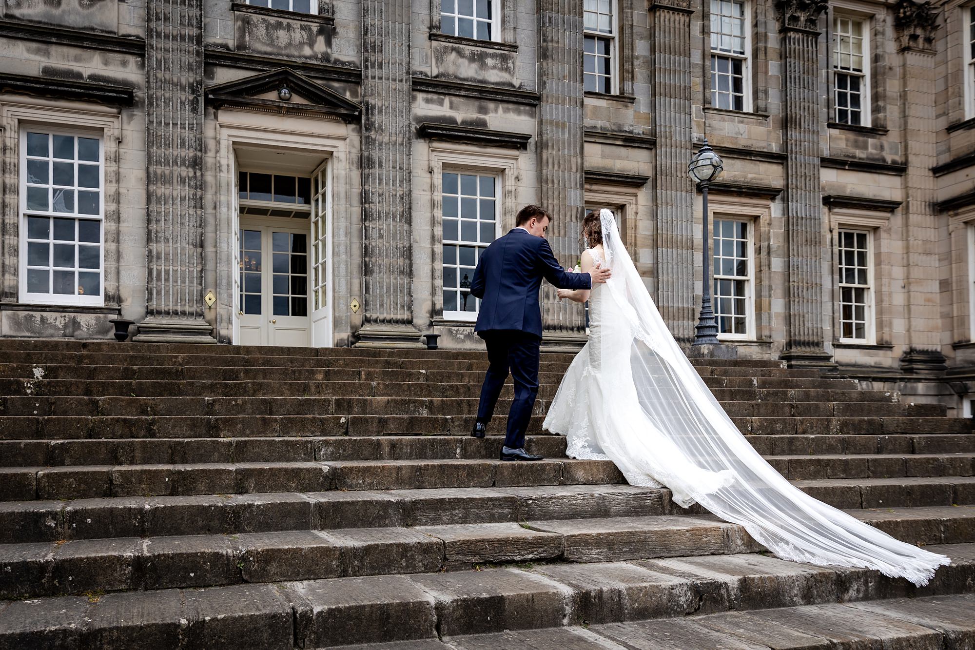bride walking up the staircase outside Hopetoun House wedding