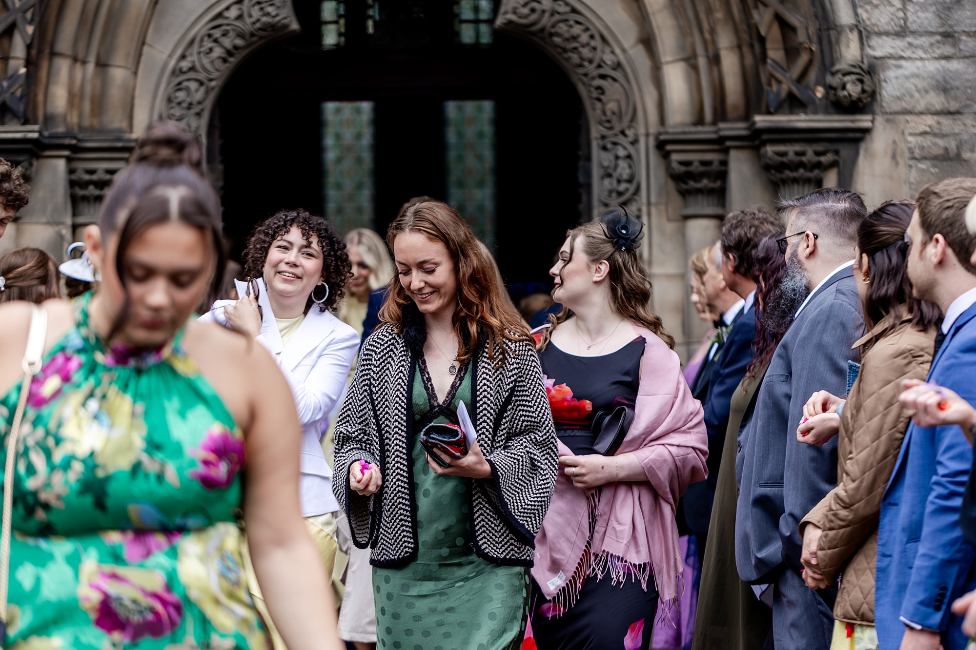 wedding guests leaving St Mary's Episcopal Church in Edinburgh wedding with handfuls of confetti