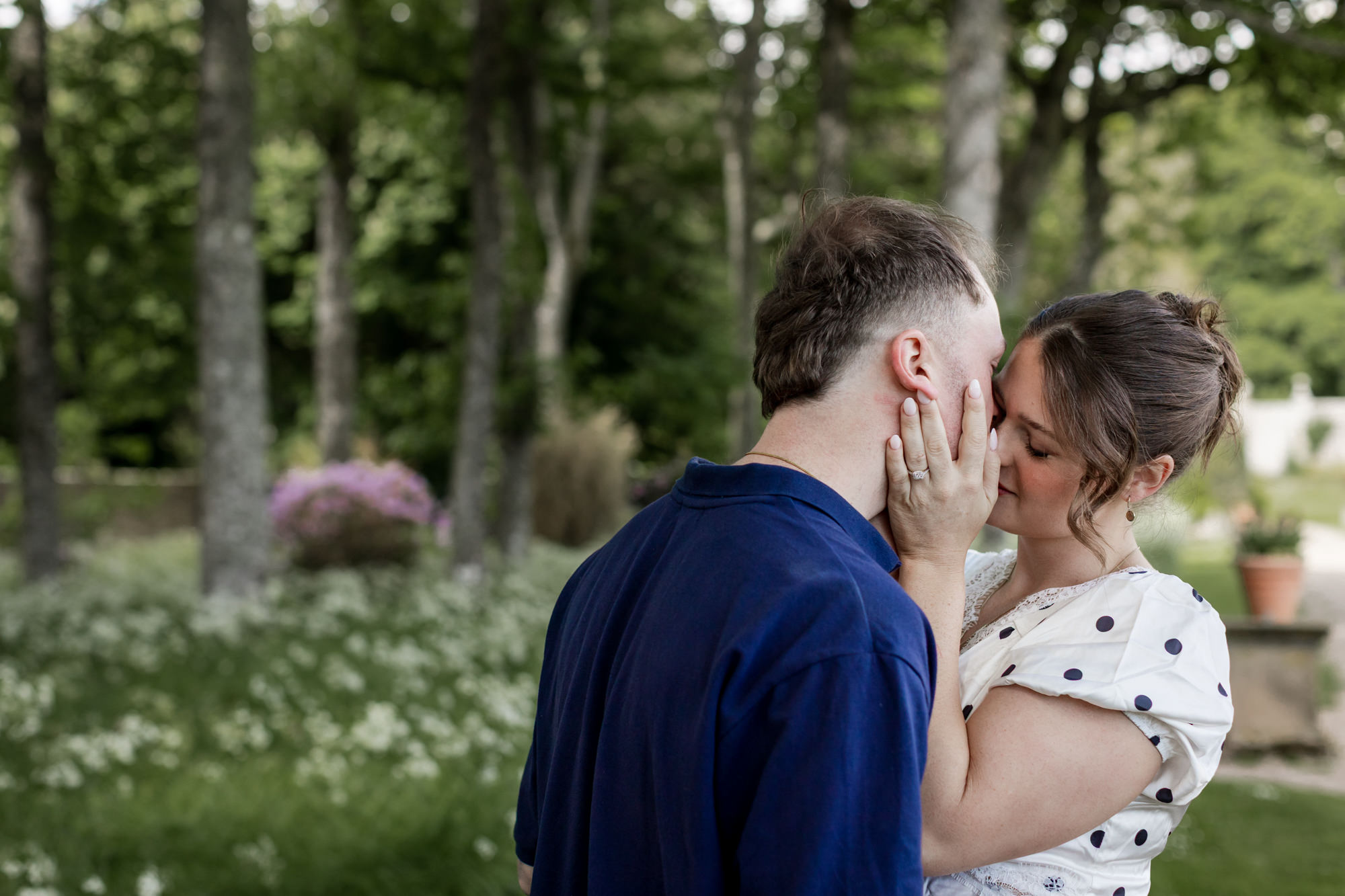 woman cupping man's face for a kiss in the gardens at Dunrobin Castle