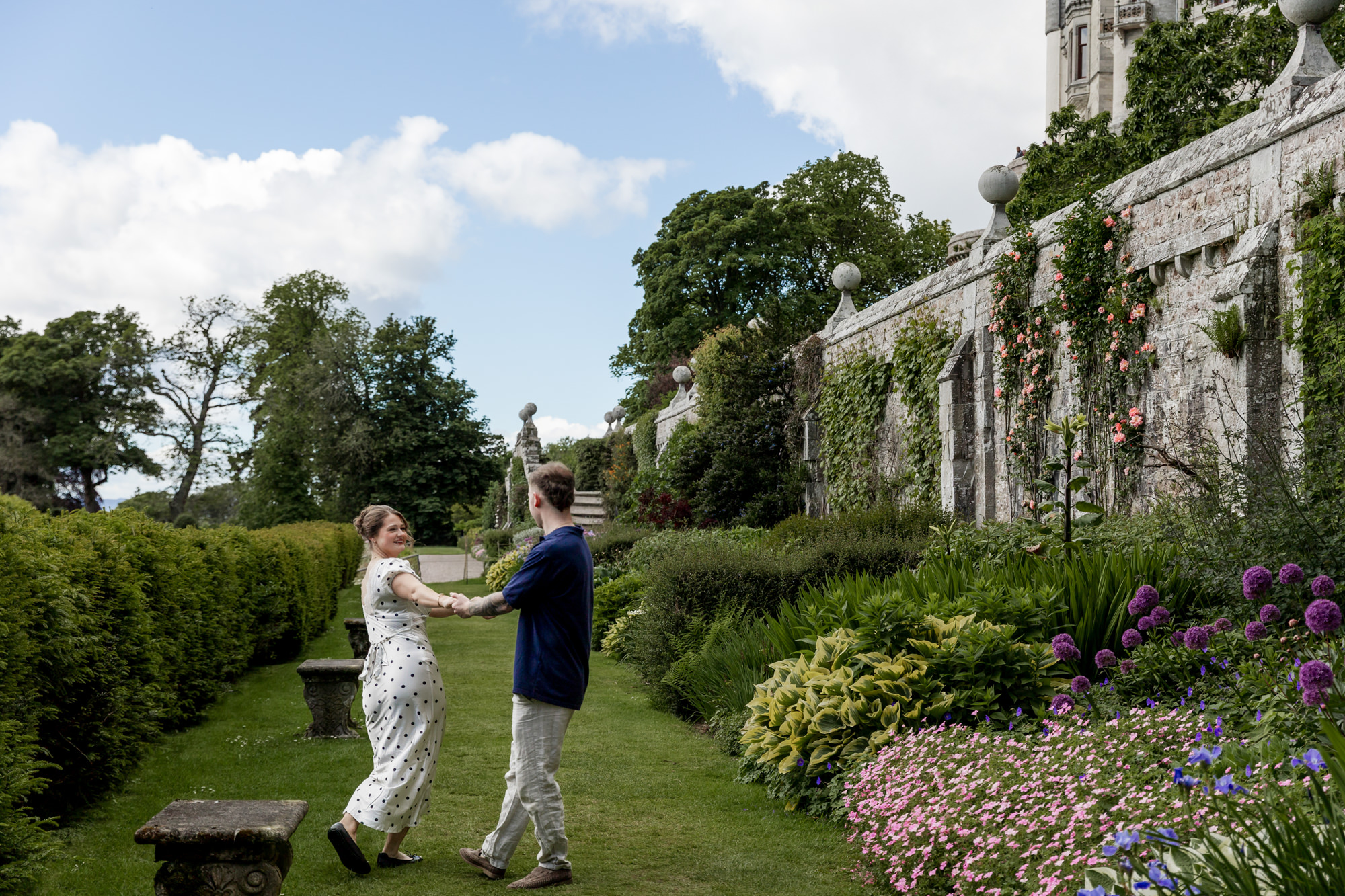 newly engaged couple playing together in the garden at Dunrobin Castle, in the Scottish Highlands. 