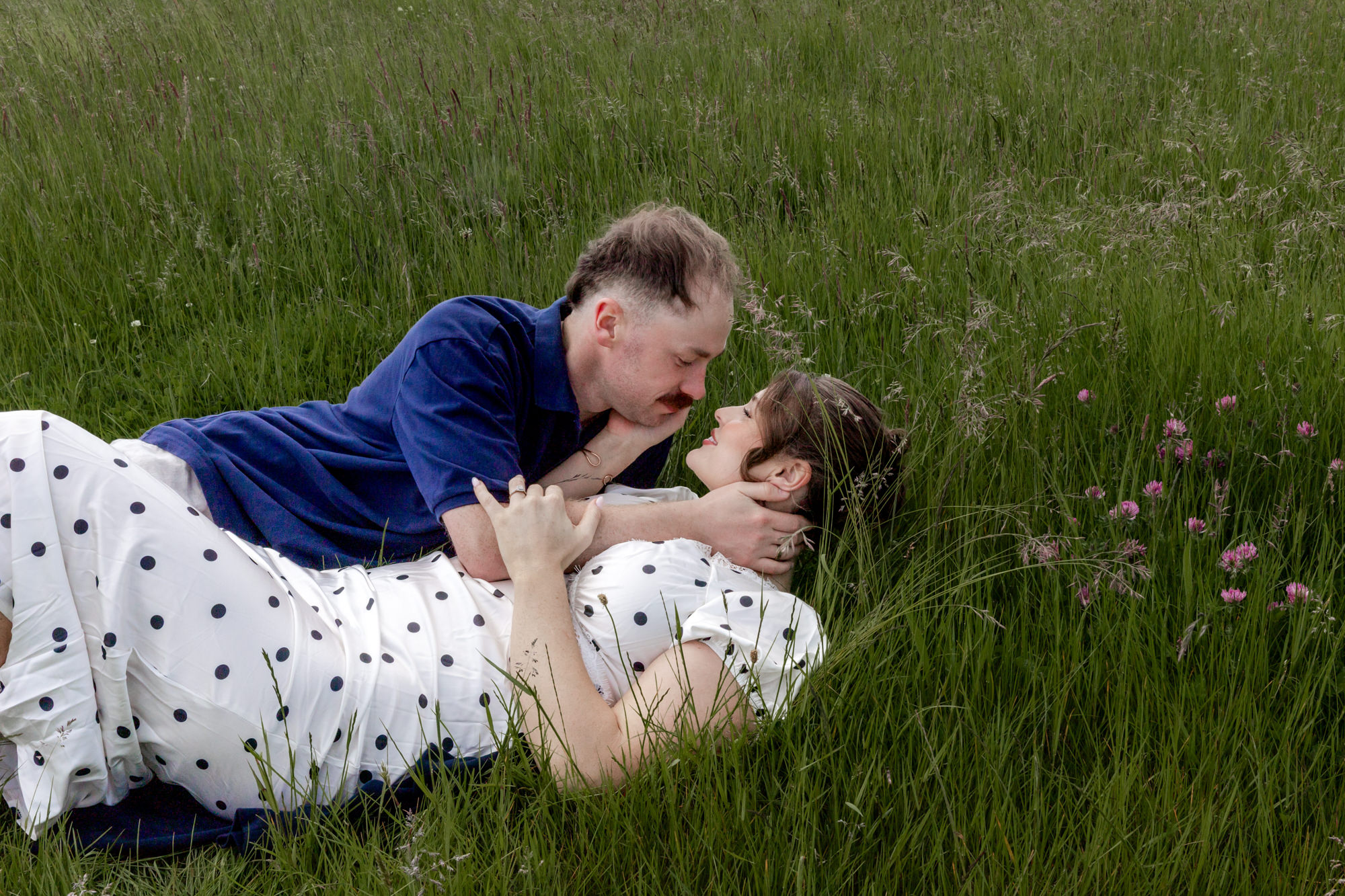 man cuddling his fiancee in the long grass 