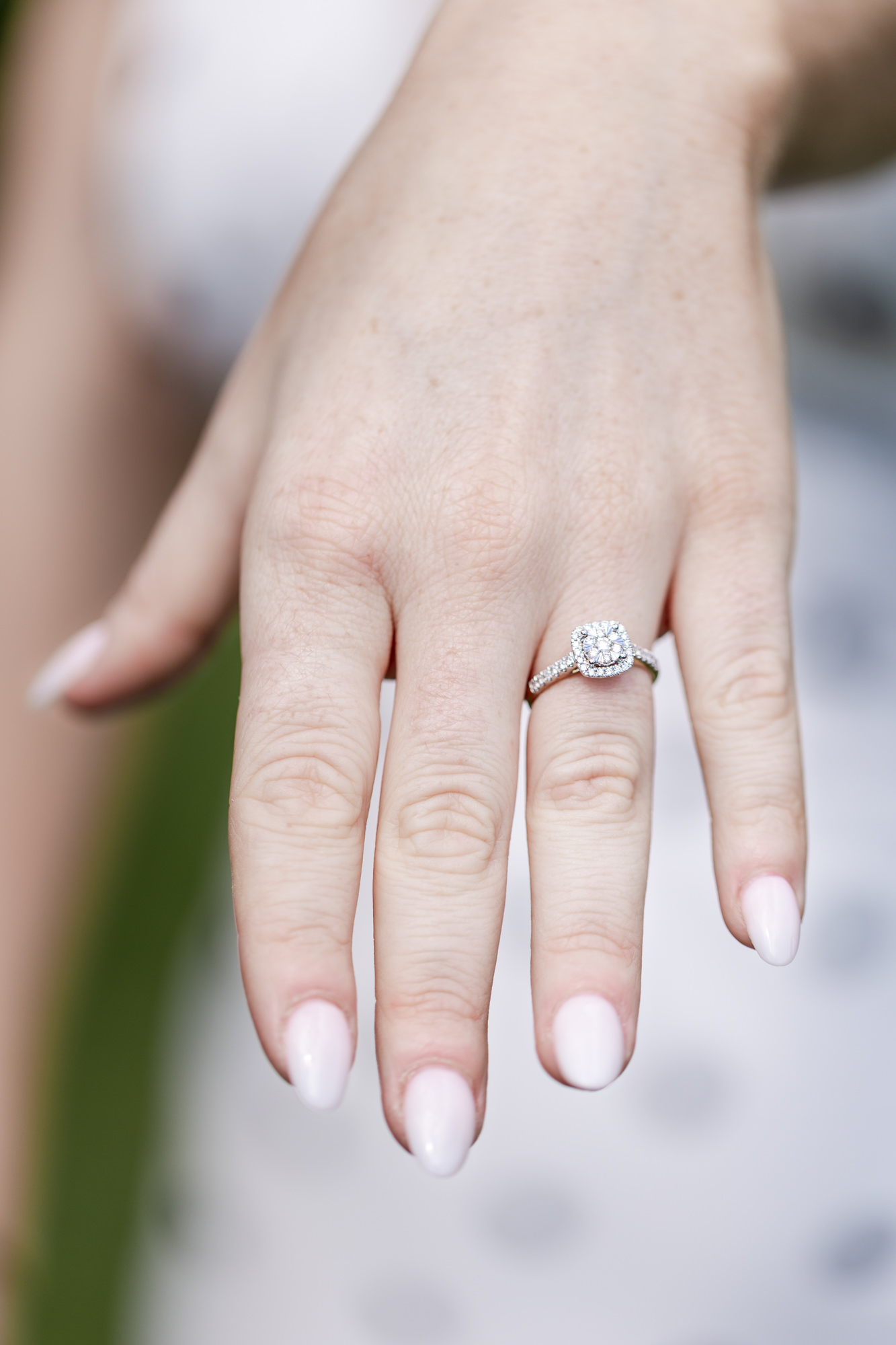 woman's hand with a diamond engagement ring on her finger
