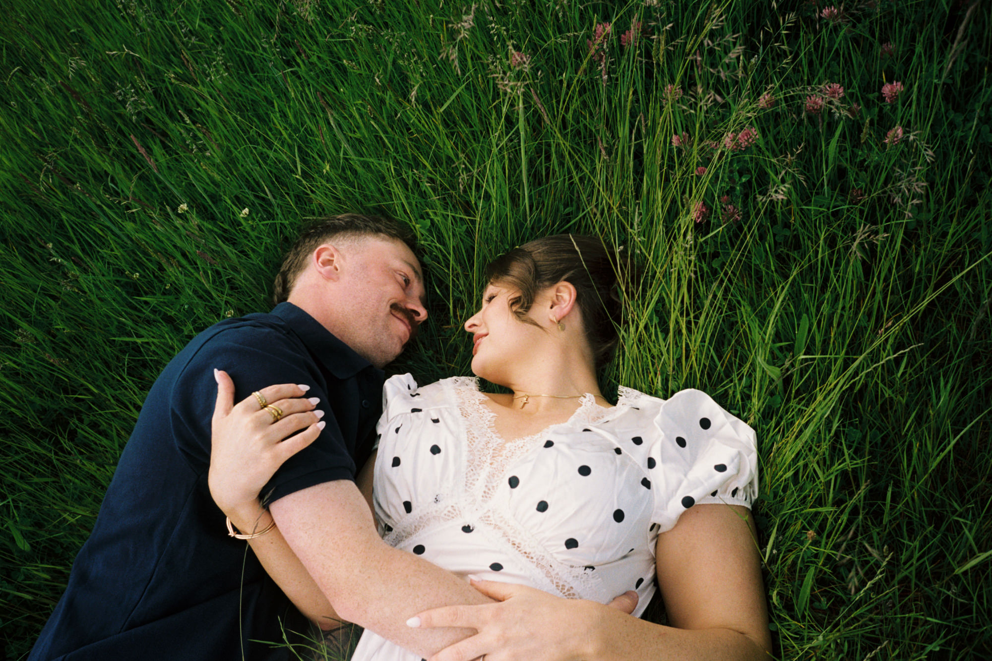 man and woman cuddling in long grass, taken on 35mm film 