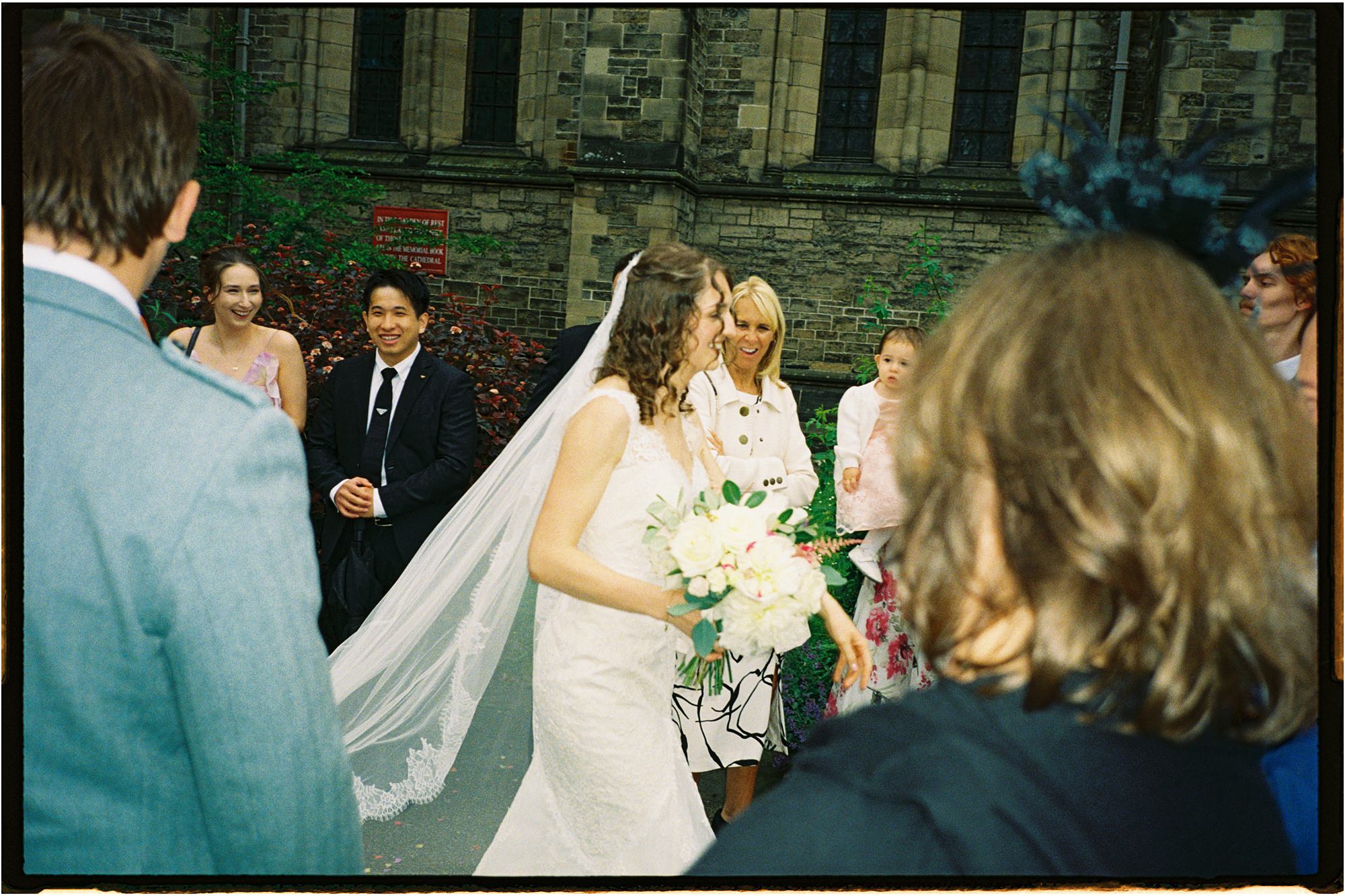 bride passing through her wedding guests outside St Mary's Episcopal Church in Edinburgh analogue photograph