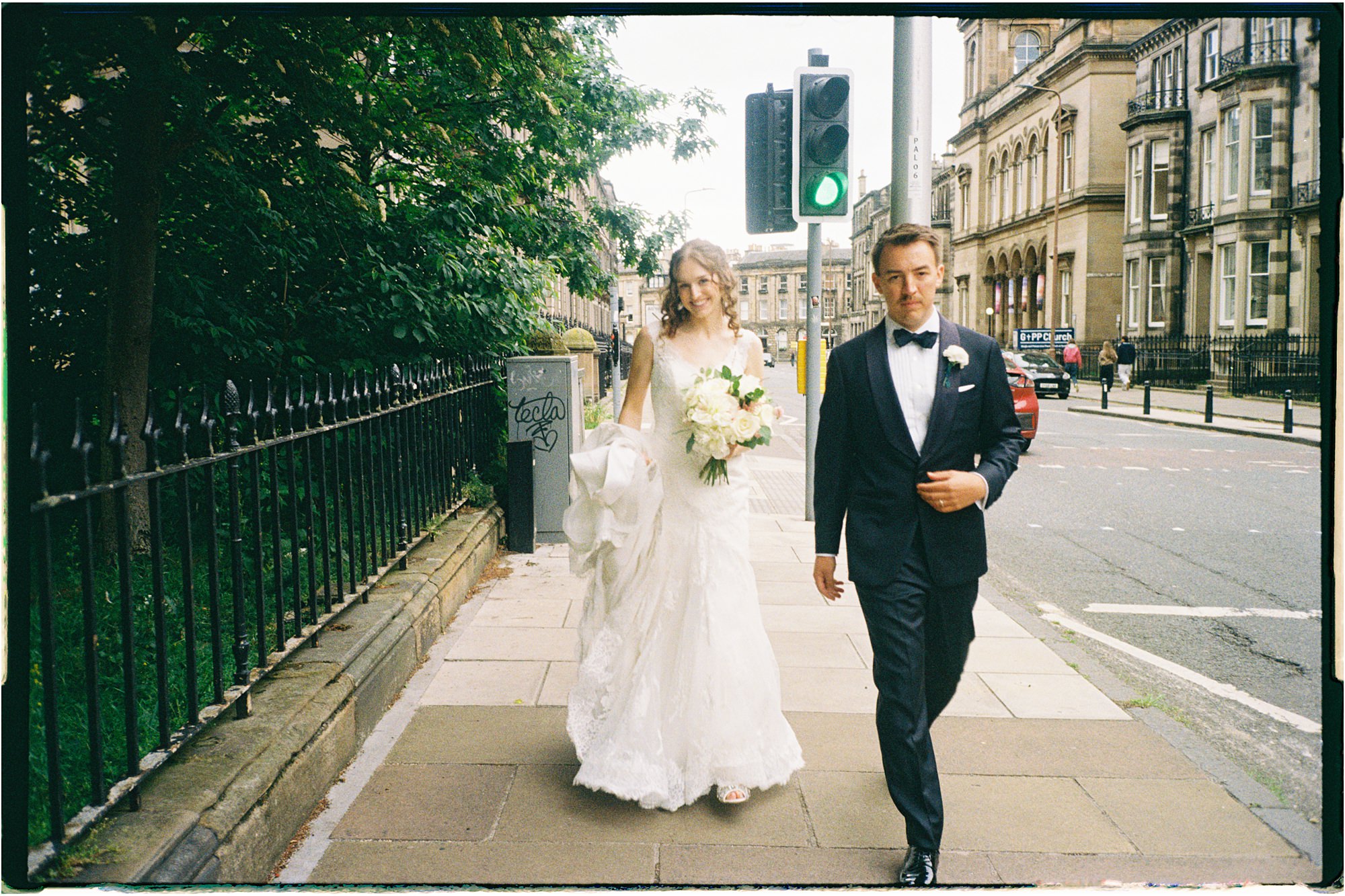 analogue photo of bride and groom on the street outside St Mary's Episcopal Church in Edinburgh