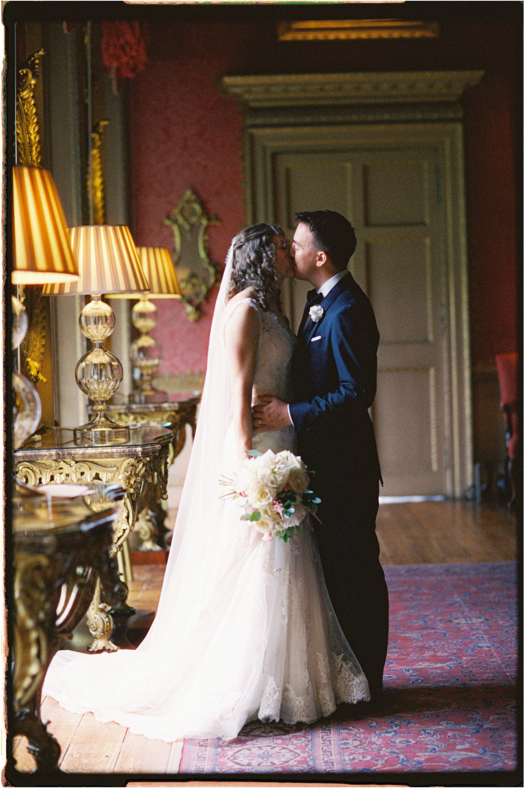 bride and groom kissing in the red drawing room at Hopetoun House, taken on 35mm film