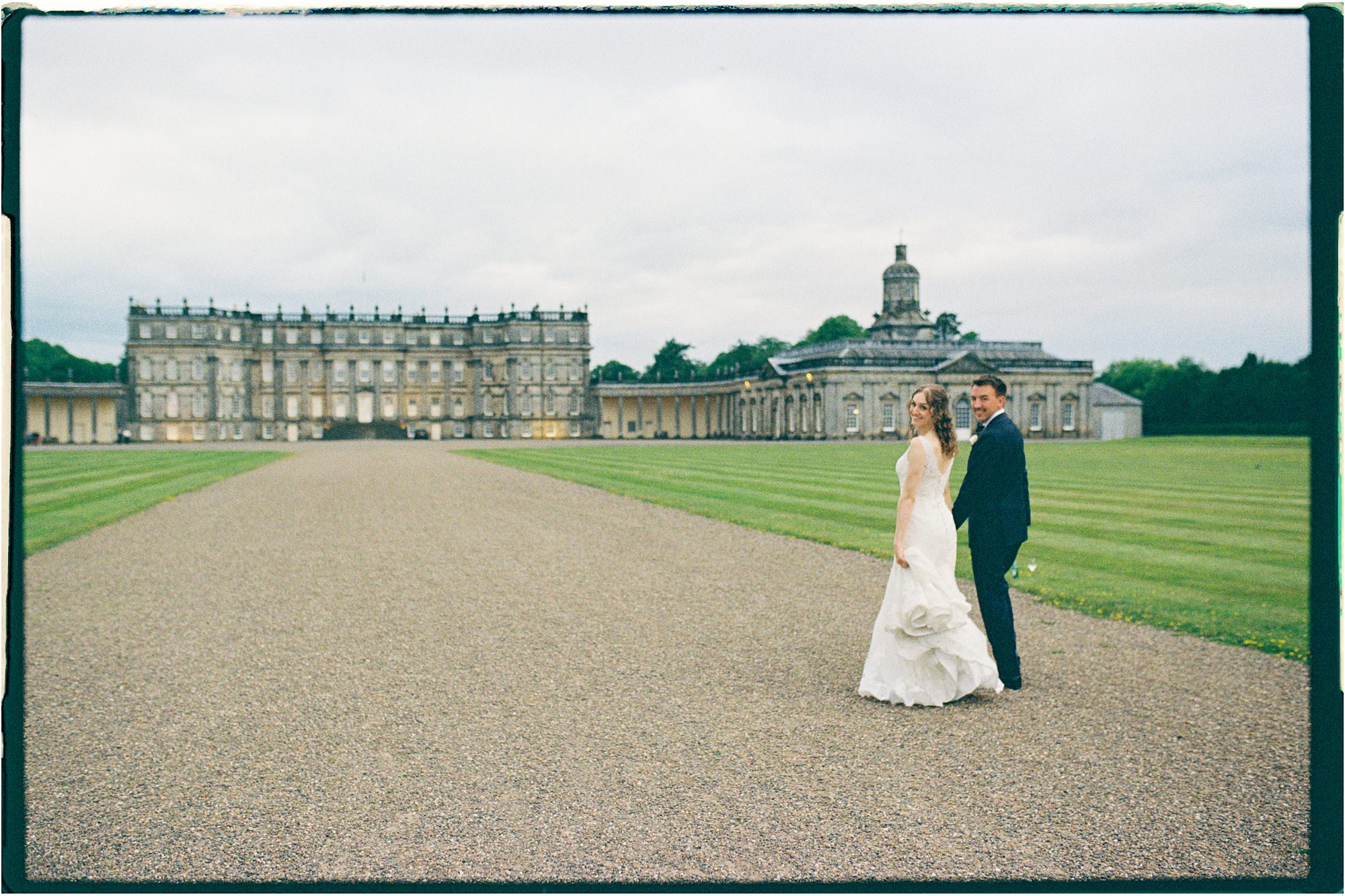 bride and groom walking along a driveway at outside Hopetoun House, taken on analogue 35mm film